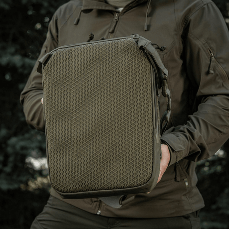 M-Tac Tablet Bag Laser Cut Hex holdt av person, laget i Cordura, med MOLLE-frontpanel, ideell for EDC, nettbrett og dokumenter.