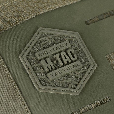 Nærbilde av M-Tac Tablet Bag Laser Cut Hex-logo i en sekskant på frontpanelet, laget av Cordura Hex-materiale i olivengrønt.