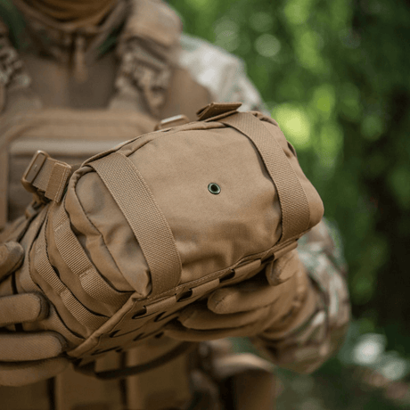 M-Tac Sukharka Gen.3 Pouch i robust Cordura 500D med MOLLE-interface, egnet for feltbruk og militær anvendelse, holdt av en person.
