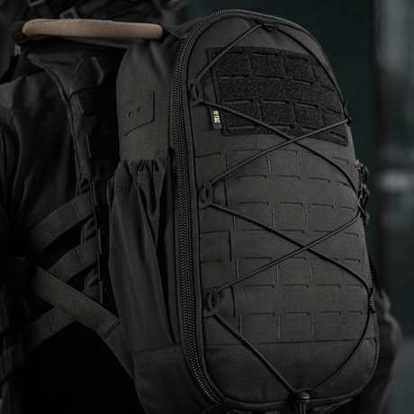 M-Tac STURM Elite ryggsekk med MOLLE Laser Cut-design og Cordura-materiale på en persons rygg, sett fra siden.