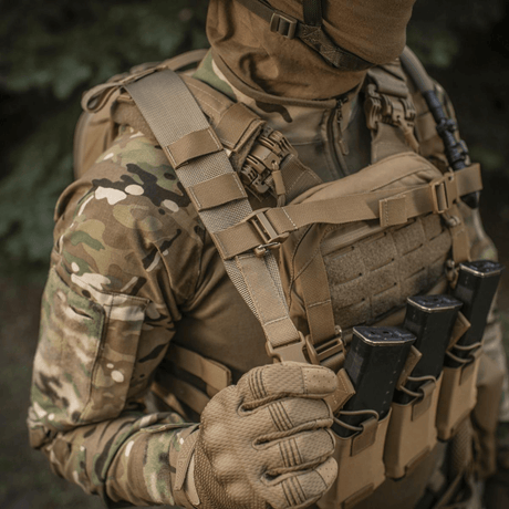 Person iført taktisk utstyr med M-Tac STURM Elite ryggsekk i skogmiljø.