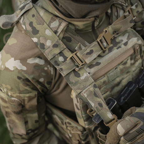 Person i kamuflasjeuniform med taktisk vest i nærbilde, viser MOLLE Laser Cut systemet brukt til M-Tac STURM Elite ryggsekk.
