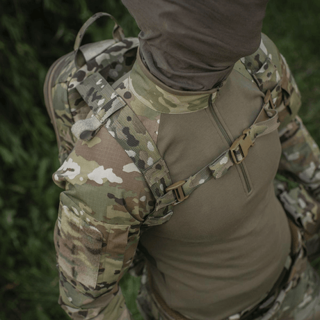 Person iført taktisk klær og M-Tac STURM Elite ryggsekk, egnet for utflukter i feltet, med slitesterkt Cordura og MOLLE-design.