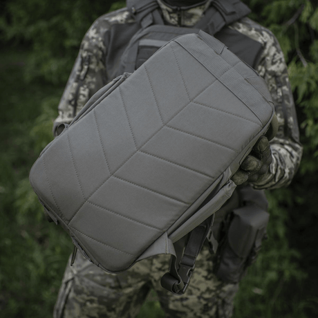 M-Tac STURM Elite ryggsekk i taktisk design, 15 liters kapasitet, slitesterkt Cordura-materiale, holdt av person i kamuflasjeuniform.
