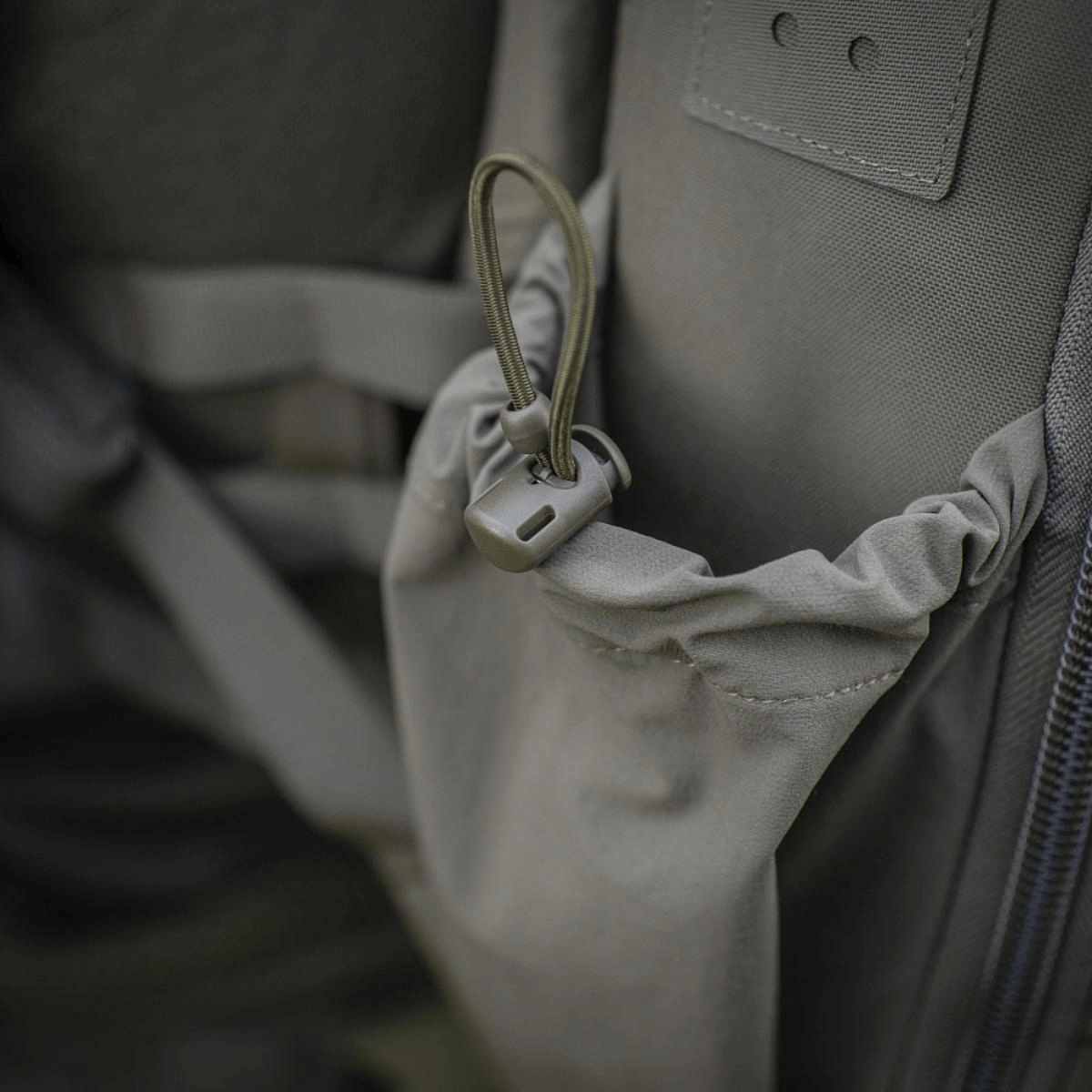 Nærbillede af sort rygsæk med lynlås og justerbar strop.