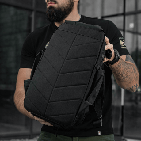 M-Tac STURM Elite ryggsekk holdt av modell utendørs, viser taktisk design og holdbarhet, egnet for korte opphold i feltet.