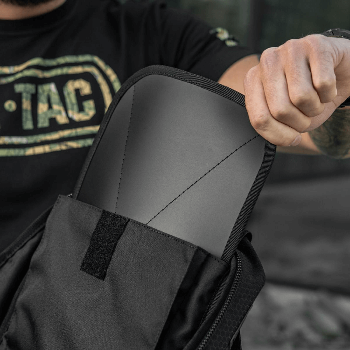 Person viser M-Tac STURM Elite Rygsæk med indbygget rygpude og MOLLE system, ideel til taktisk brug og udstyrstransport.