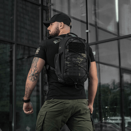 Mann iført M-Tac STURM Elite ryggsekk på 15 liter, svart, designet for korte opphold i feltet, med MOLLE Laser Cut panel.