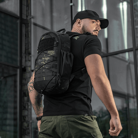 Mann iført M-Tac STURM Elite ryggsekk med MOLLE Laser Cut-frontpanel i utendørs miljø.