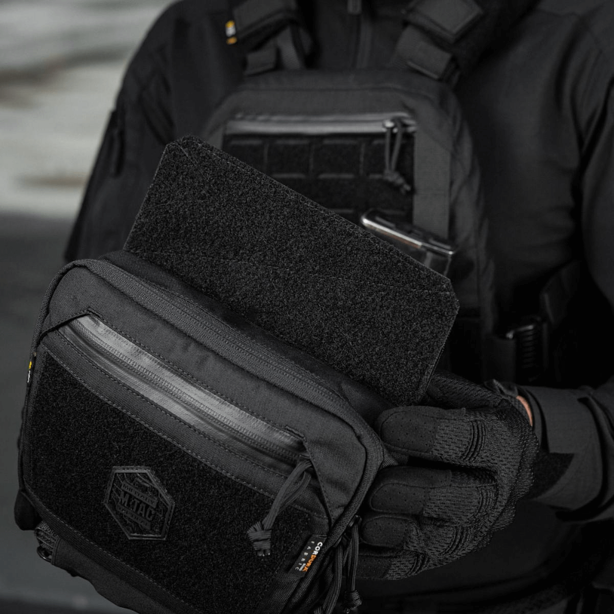 M-Tac Large Elite Gen.II Skuldertaske med Cordura 500D materiale og YKK lynlåse, viser front Velcro-panel med logo.