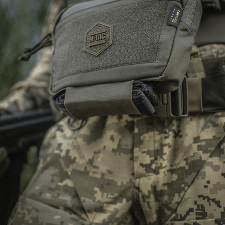 M-Tac Large Elite Gen.II skulderveske, taktisk skulderveske i Cordura 500D med YKK-lynlåser, sett på uniform i kamuflasjemønster.