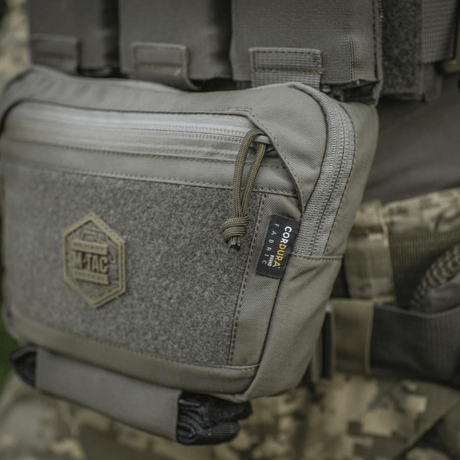 M-Tac Large Elite Gen.II skulderveske i bruk, Cordura 500D stoff og YKK-lynlåser, vist på taktisk utstyr.