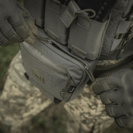 M-Tac Large Elite Gen.II skulderveske i Cordura 500D, brukt utendørs, viser veskens holdbarhet og lynlåsfunksjon.