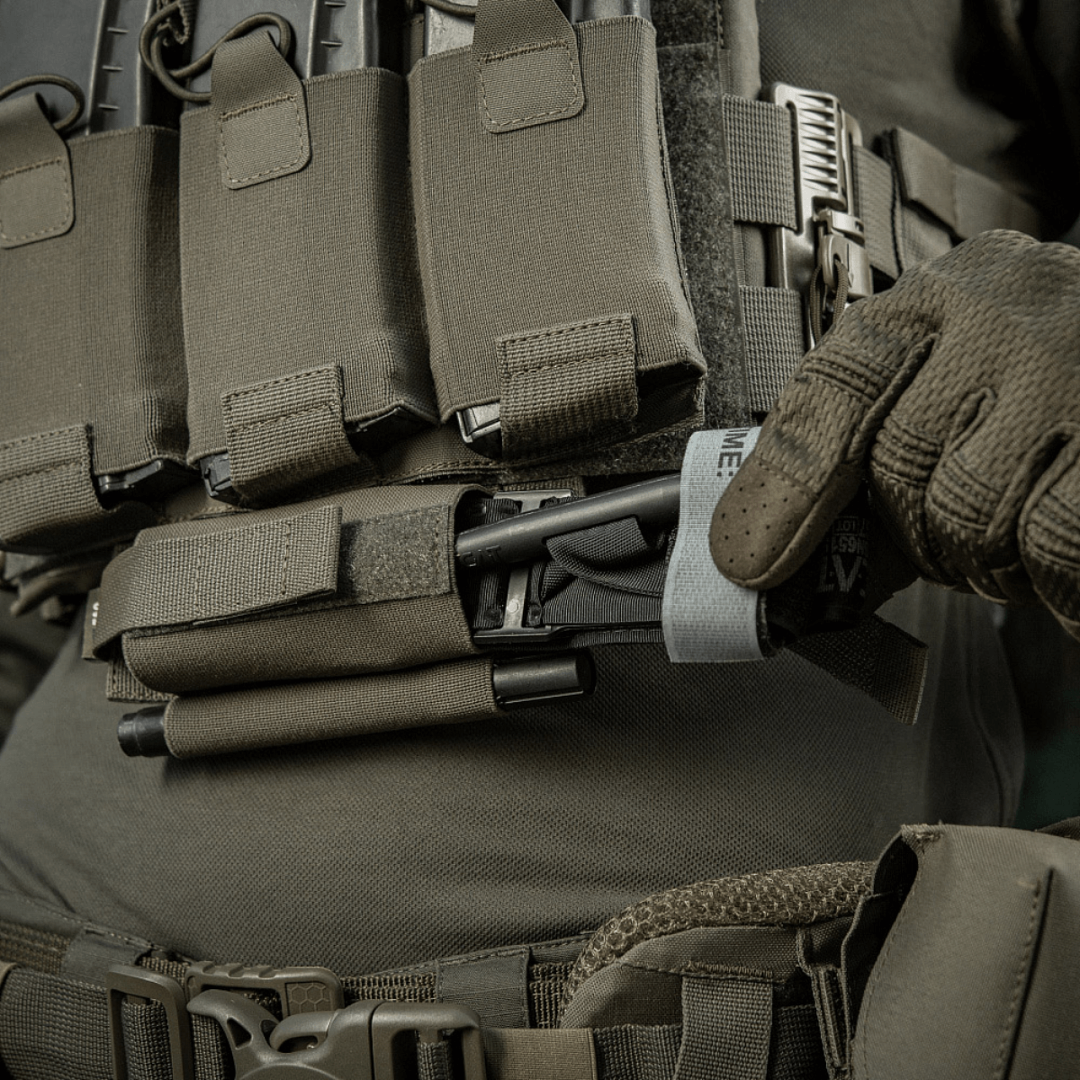 M‑Tac Tourniquet Pouch Elastic Gen.5 monteret på taktik udstyr, hurtig adgang og sikker opbevaring til CAT tourniquet, lavet af Cordura 500D.