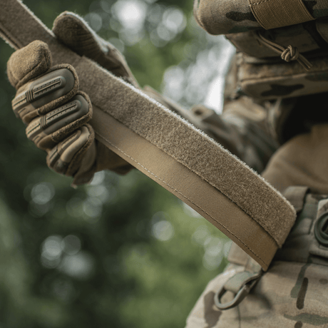 M‑Tac Internal Tiger Bælte holdt av taktisk kledd person, perfekt for militær og taktisk bruk.