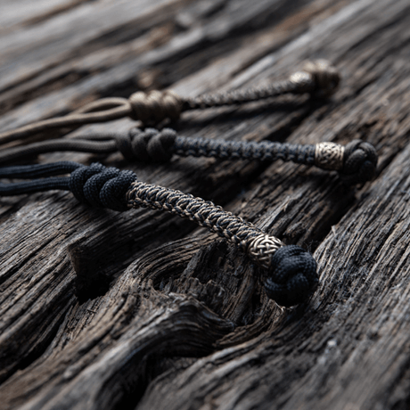 M-Tac Knife Lanyard Scandinavian flettet paracord-tillegg til lommekniver på treflate, stilfullt og praktisk tilbehør.