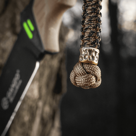 M-Tac Knife Lanyard Scandinavian Granule i flettet paracord med dekorativ knute festet til kniv, praktisk og stiligt tilbehør.