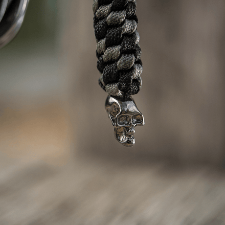 M-Tac Knife Lanyard Helix Skull med flettet paracord og kraniedesign, tilfører stil til lommekniver og gjør det enkelt å håndtere.