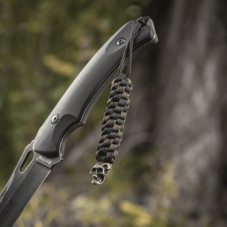 M-Tac Knife Lanyard Helix Skull på en kniv, flettet paracord tilfører stil og funksjonalitet med et karakteristisk kraniedesign.