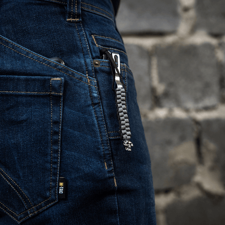 M-Tac Knife Lanyard Cuboid Skull festet i jeans med paracord-flettet design og dekorativ kranieperle.