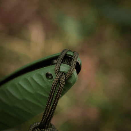 M-Tac Knife Lanyard Celtic på en grå kniv til utendørs bruk, fremhever et stilfullt, flettet design laget av holdbar paracord.
