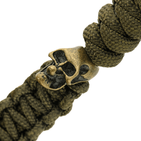 Detalj av olivengrønn M-Tac Loopy Snake Skull Lanyard, vist med flettet paracord og dekorativt kranium i metall, til kniv og utstyr.