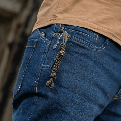 M-Tac Loopy Snake Skull Lanyard i paracord på jeans, stilfullt og praktisk tilbehør til kniver, lykter og annet utstyr.
