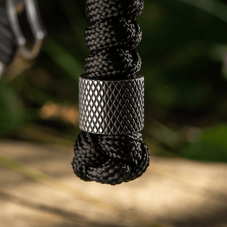 M-Tac Viper Lanyard Stainless Steel med flettet paracord og Viper-perle i rustfritt stål, fremhever kniven stilfullt.