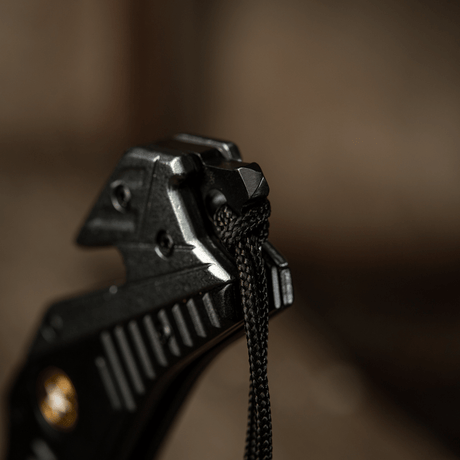 Detaljbilde av M-Tac Zeus Lanyard, flettet med paracord for rask tilgang og stilfullt design, festet til knivhåndtak.