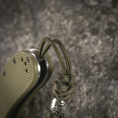 M-Tac Zeus Stainless Steel Lanyard med flettet paracord og dekorativ bead, festet til kniv for fleksibel tilgang og holdbarhet.