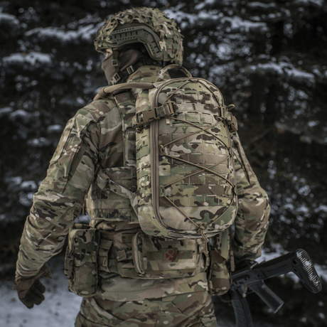 Soldat iført M-Tac ryggsekk Sturm Elite Gen.II i snødekt skog med MOLLE Laser Cut-system og elastisk snøring for utstyr.