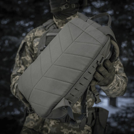Taktisk M-Tac ryggsekk Sturm Elite Gen.II holdt av en person i kamuflasjeutstyr.