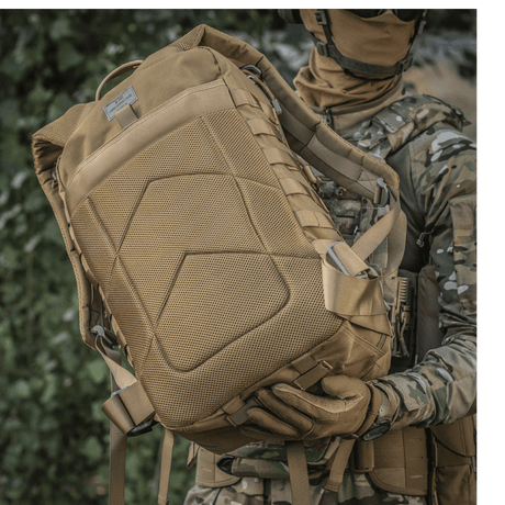 Soldat med M-Tac Large Assault Pack ryggsekk i urban kamuflasjemønster, viser MOLLE-system og komfortable skulderremmer.