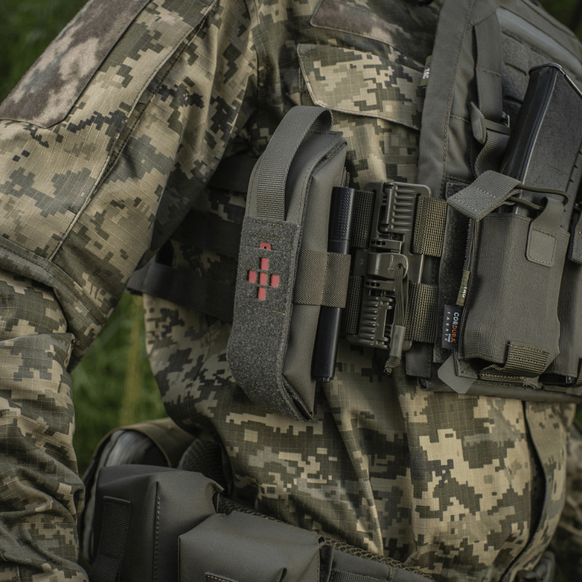 M-Tac Lomme til Tourniquet Closed i brug med camouflagedragt, viser tourniquet opbevaring i nødsituationer.