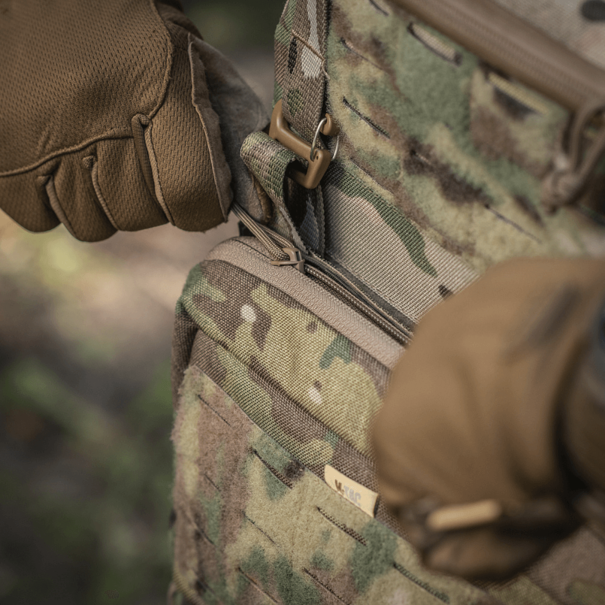 Close-up af M-Tac Admin Pouch Large Elite i brug, viser robust Cordura materiale og taktisk lynlåsdesign i naturmiljø.