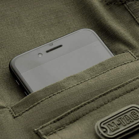 Lomme på M-Tac Shorts Aggressor Gen.II Flex med smartphone, viser holdbar og vandafvisende rip-stop materiale, perfekt til træning.