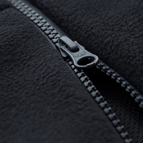 Close-up af lynlås på M-Tac Lite Microfleece Hættetrøje i sort mikrofleece materiale, viser detaljeret struktur og lynlåsdesign.