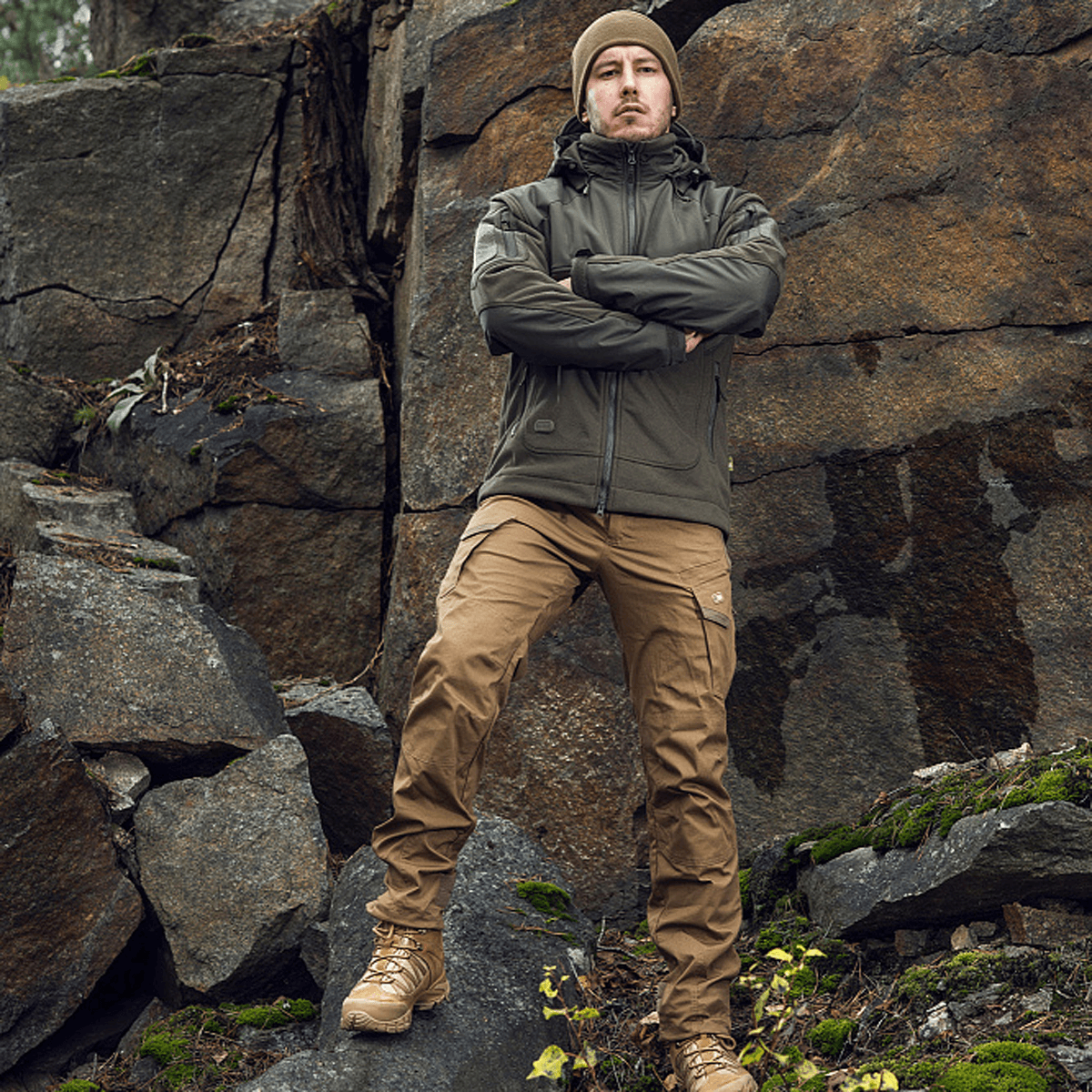 Mand iført M-Tac Norman Windblock Fleecejakke, står i stenet terræn, designet til komfort og varme mod vind og kulde.