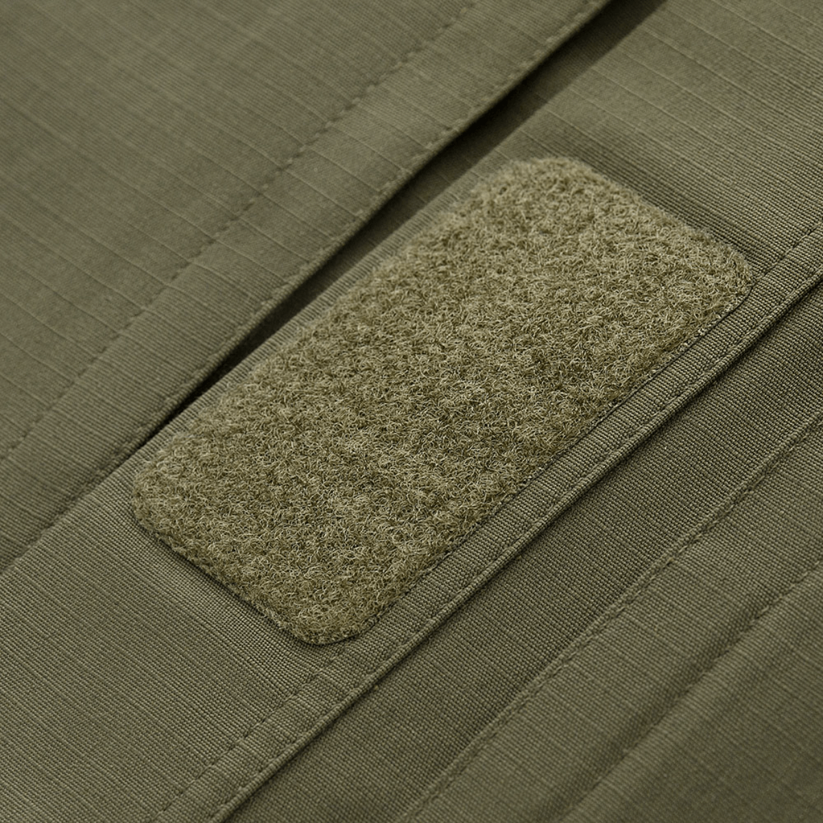 Close-up of Velcro panel on M-Tac Jakke Patrol Flex, showcasing durable tactical design in green fabric.