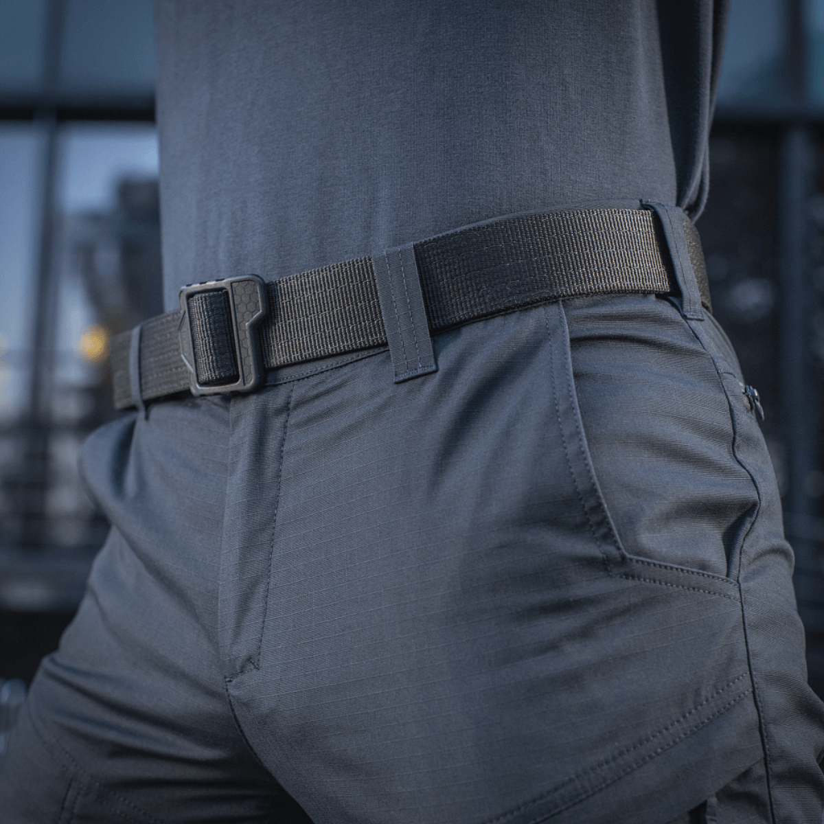 Mand iført M-Tac Tactical Bukser Patrol Gen II Flex med sort bælte, viser detaljeret design og funktionalitet.