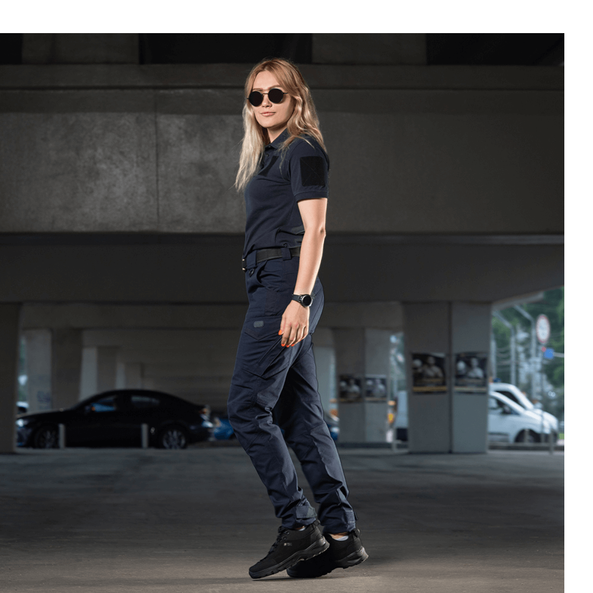 Kvinde i M-Tac Bukser Aggressor Dame Flex til udendørs aktiviteter, viser stilfuldt og funktionelt design i bymiljø.