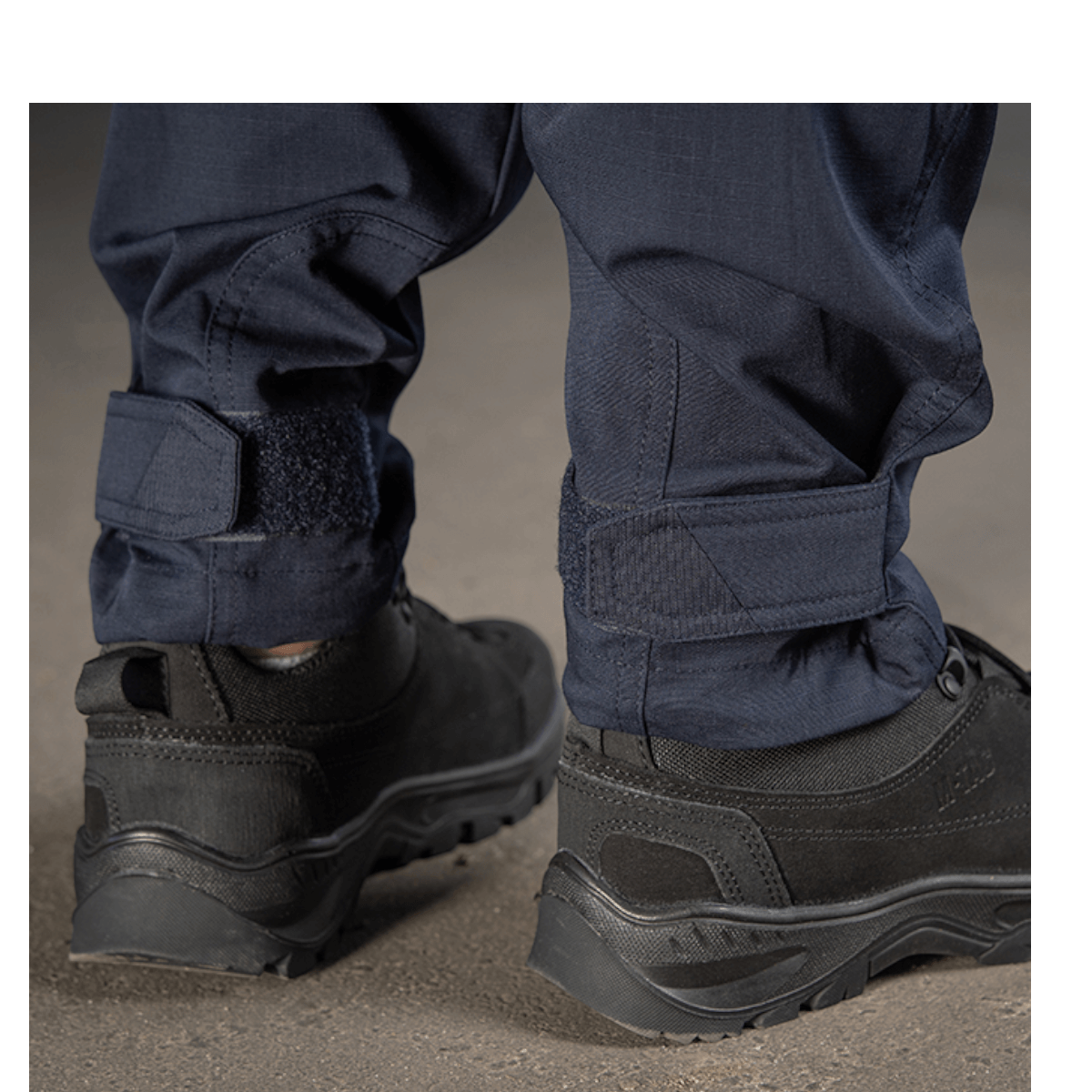 Detalje af M-Tac Bukser Aggressor Dame Flex i blåt stof. Vist med sorte sko, fremhæver robust design og holdbare materialer.