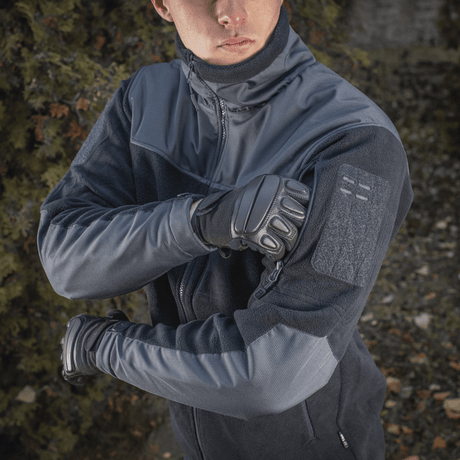 En person iført M-Tac Alpha Microfleece Jakke Gen.II i mørke toner, perfekt til taktisk og outdoor-brug i koldt vejr.