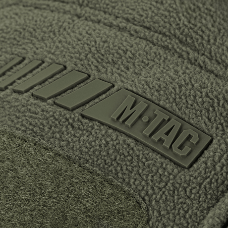 Detalje af M-Tac Division Gen.II Windblock Fleecejakke viser mærkelogo på olivengrøn polyester.