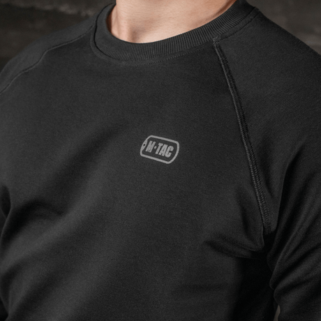 M-Tac Raglan Athlete i svart med raglanermer for maksimal bevegelsesfrihet og komfort, ideell for daglig bruk og sport.