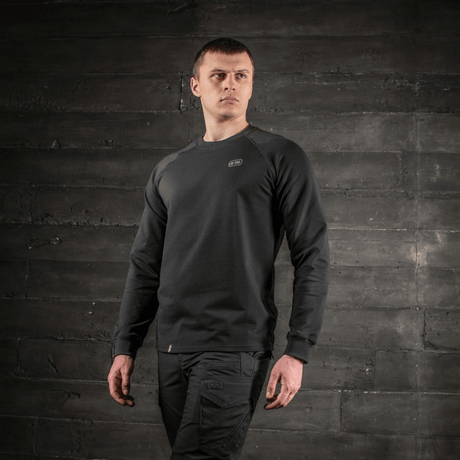 Mann iført M-Tac Raglan Athlete i svart med raglanermer for optimal bevegelse, allsidig sweatshirt til sport og hverdag, sett forfra