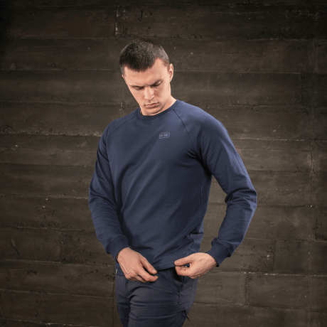 Mann iført M-Tac Raglan Athlete-sweatshirt i mørkeblå med raglanermer og rund hals for optimal bevegelsesfrihet.