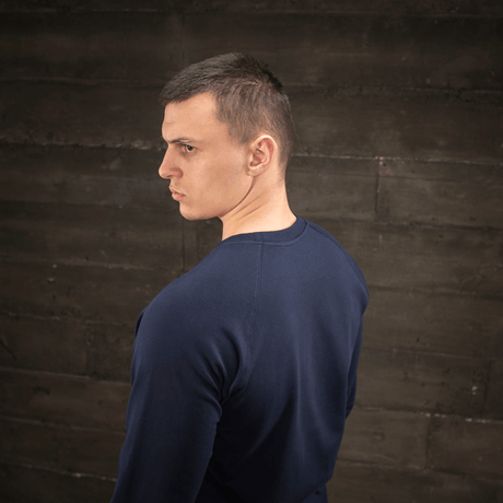 Mann iført M-Tac Raglan Athlete-sweatshirt med rund hals og raglanermer i marineblå, sett fra siden, ideell for sport og hverdag.