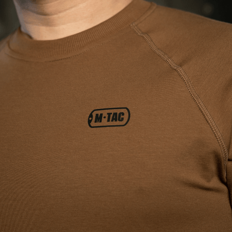 M-Tac Raglan Athlete-sweatshirt i coyote med komfortable raglanermer, ideell for sport og hverdag, nærbilde av logoet.
