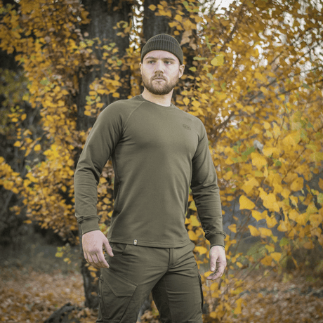 Mann iført M-Tac Raglan Athlete-sweatshirt i olivengrønn om høsten.
